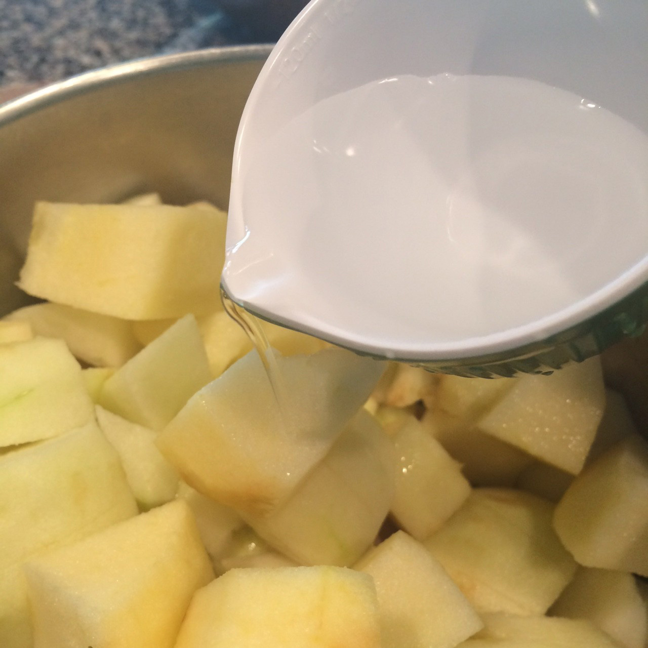 pouring water on to apple cubes